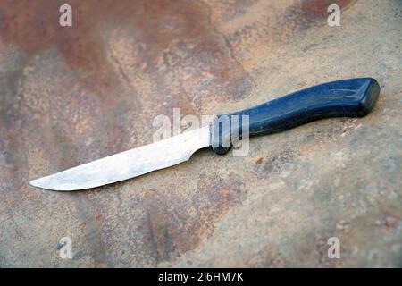 An old blunt kitchen knife with a black plastic handle Stock Photo
