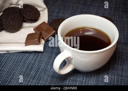 White cup with dark coffee and sweets, close-up Stock Photo