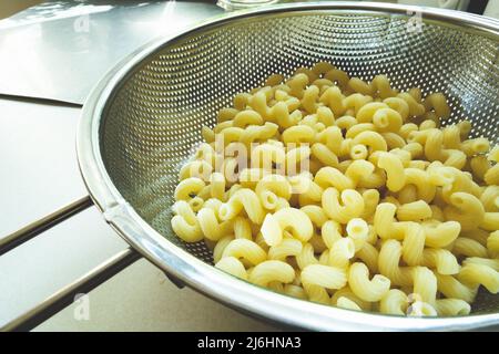 Fresh pasta in a stainless steel silver strainer Stock Photo
