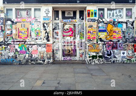 Graffiti art and text covering the shopfront of a closed shop in Brick Lane London England UK   KATHY DEWITT Stock Photo