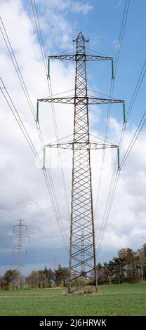 high voltage pole on a green field, Denmark, May 1, 2022 Stock Photo