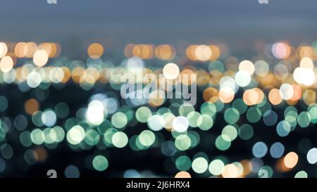 Defocus cityscape at twilight, bright and colourful blurred background with bokeh circle round lights, abstract bokeh creative background. Stock Photo