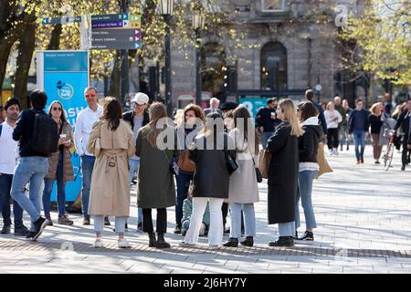 Group of tourists on walking tour of Belfast City Centre in Donegall Square outside Belfast City Hall, Northern Ireland, 20th April 2022. Stock Photo