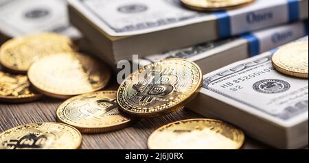 Gold Bitcoins on American Banknotes. Online trading between US currency and cryptocurrency. Stock Photo