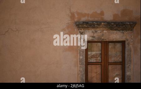 Traditional rural house wooden window on a Venetian stucco wall in Monemvasia, Laconia Peloponnese, Greece. Stock Photo