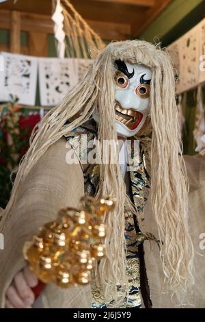 Fujisaki-san, a master of Kagura the Shinto ritual performance telling the stoires of the gods. Wearing the white mask to perform The Dance of Tajikar Stock Photo