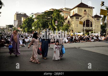 Muslims offer prayers during Eid 1443 Hijriyah / 2022 AD near a church in Jatinegara. This year, the Indonesian government allowed Eid prayers to be held together after two years of being canceled due to the Covid-19 pandemic. Stock Photo