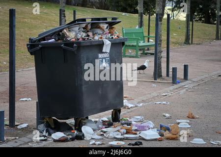 Overflowing waste bin in the park after May Day celebrations in Helsinki, Finland. Stock Photo