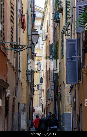 Tourists stroll down a narrow street in Nice Old Town. France. Stock Photo