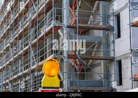 Shell of an apartment building with scaffolding and warning light in the foreground in Bad Homburg (Vickers - Areal) near Frankfurt on the Main Stock Photo