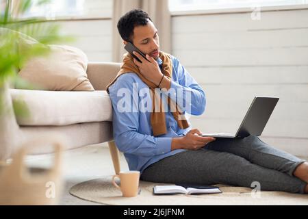 Arab man working and talking on phone at home Stock Photo