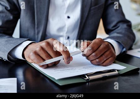 Close up of successful African American executive holding pen in hand while taking notes at business meeting Stock Photo