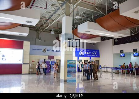 Aktau, Kazakhstan - May 21, 2012: Aktau international airport modern terminal interior. Passengers on reception desk, right. Stock Photo