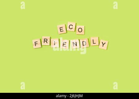 Eco Friendly written with wooden letter blocks on a green background Stock Photo
