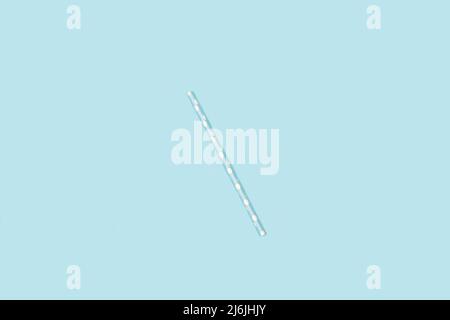Light blue with white polka dot drinking straw on a light blue background with copy space Stock Photo