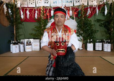 Fujisaki-san, a master of Kagura the Shinto ritual performance telling the stoires of the gods. With the red mask of The Totori Dance. Takachiho, Kyus Stock Photo