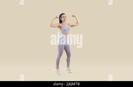 Full length studio shot of happy woman in sportswear showing her fit, strong, healthy body Stock Photo