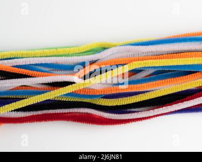 A quantity of Neon rainbow colored pipe cleaners on a white background Stock Photo