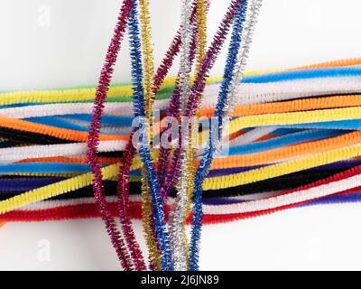 sparkle neon craft pipe cleaners on a bed of rainbow cleaners Stock Photo