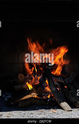 Bonfire close up of charged and burning logs sticks and twigs Stock Photo