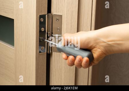 Carpenter installs a door hinge. Stock Photo