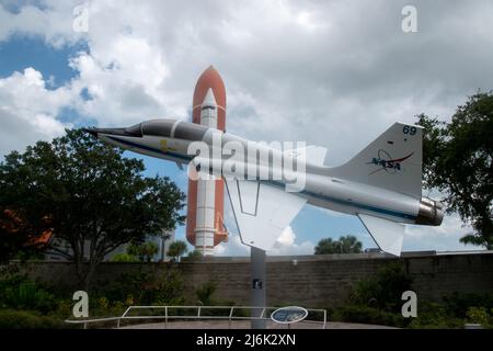 Cape Canaveral, FL - Sep 10 2021: A NASA T-38 Talon research airplane with an orbital booster in the background from the Kennedy Space Center Stock Photo