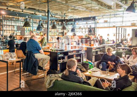 People relax at a restaurant bar at Helsinki Vantaa International Airport Finland in Helsinki, Finland on a sunny day. Stock Photo