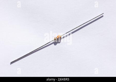 A close up portrait of a 330 ohm resistor with a 5% tolerance. The electronic component is isolated on a white background and is ready to be used in a Stock Photo