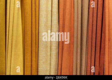 Background Texture Of A Selection Of Multiple Different Warm-Colored Fabric Samples Stock Photo