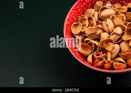 Organic Pistachio Shells in a Flowery Bowl on top of a Green Stock Photo