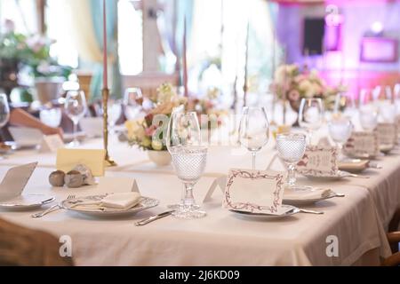 Luxurious table setting for a holiday in pastel colors close-up.Empty wine glasses placed in the restaurant. Part of the interior. High quality photo Stock Photo