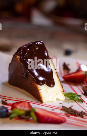 a large piece of dessert sponge cake with chocolate cream and strawberries. Stock Photo