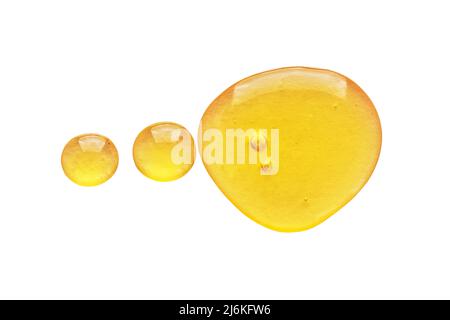 Golden yellow abstract oil bubbles or face serum drops isolated on white background. Oil bubbles macro photography. Stock Photo