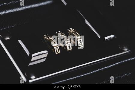 Simple code lock on a dark black premium suitcase. Belongings protection, data safety, security abstract concept, number combination lock object macro Stock Photo