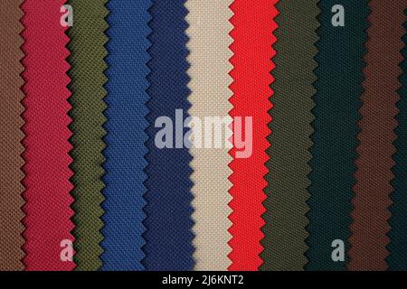Colourful samples of fabric for sewing bags and backpacks. polyester blue, green, beige and red fabric. Palette of samples of a dense fabric of differ Stock Photo