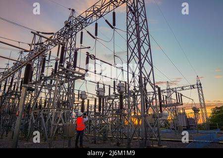Engineers are checking the operation of the system by laptop, weekly check the system of the power distribution station for errors in the distribution Stock Photo