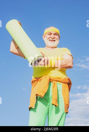 Senior sport man is doing sport outdoors. Active leisure. Sport and retirement concept. Elderly man after her workout. Elderly man practicing sports Stock Photo
