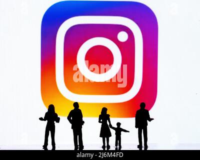 Miniature figures standing in front of an Instagram logo on the smartphone Stock Photo