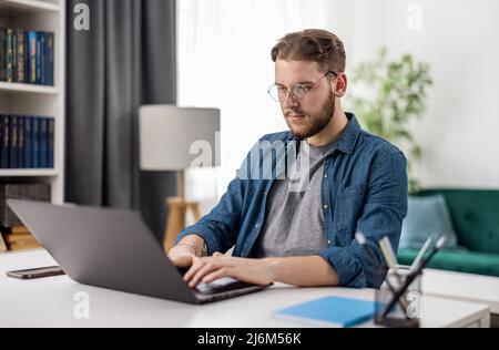 Man coding on laptop at home Stock Photo