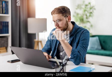 Programmer with laptop at home Stock Photo