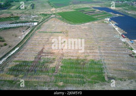 Aerial view of big electric power plant under construction with many rows of solar panels on metal frame for producing clean electrical energy Stock Photo