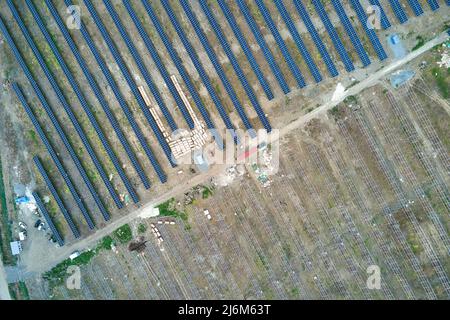 Aerial view of electrical power plant under construction with truck delivering assembly parts for solar panels on metal frame for producing electric Stock Photo