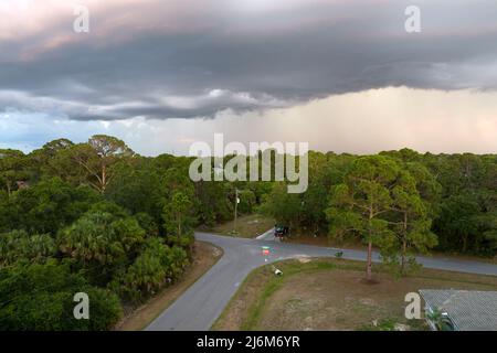 Landscape of dark ominous clouds forming on stormy sky before heavy thunderstorm over rural town area Stock Photo