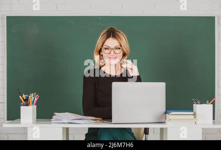 Portrait of female teacher is teaching online through webcam students with computer laptop in classroom. Stock Photo