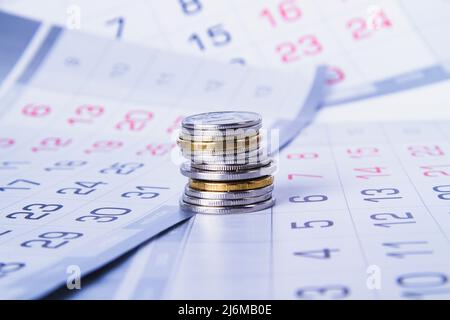 Budget planning. Money and calendar. Salary and advance. Receiving a profit. Spending schedule for the year. Annual and monthly budget. Analysis and s Stock Photo