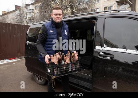 KYIV, UKRAINE 01 March. A member of the Territorial defense forces  loads Molotov Cocktails into a van as Ukrainians prepare for urban warfare in Protasiv Yar neighborhood on 01 March 2022 in Kiev, Ukraine. Russia began a military invasion of Ukraine after Russia's parliament approved treaties with two breakaway regions in eastern Ukraine. It is the largest military conflict in Europe since World War II. Stock Photo