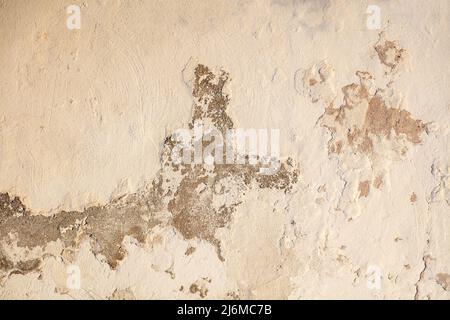 Old beige color paint faded wall texture background. Aged peeled house facade, front close up view Stock Photo