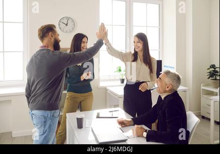 Smiling colleagues give high five celebrate business success Stock Photo