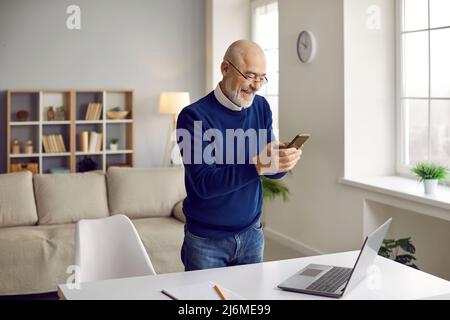 Middle-aged man work on laptop use smartphone Stock Photo
