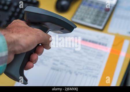 Hand reading the invoice barcode, stored data in the system, making payment.
